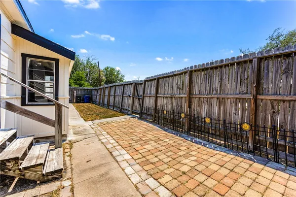 a view of house with wooden fence and a large window