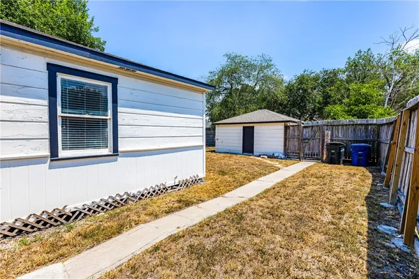 a view of backyard of house with wooden deck and seating space