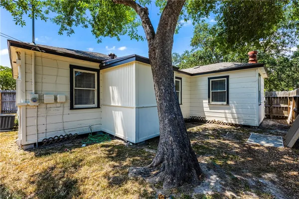 a view of a backyard with a large tree and wooden fence