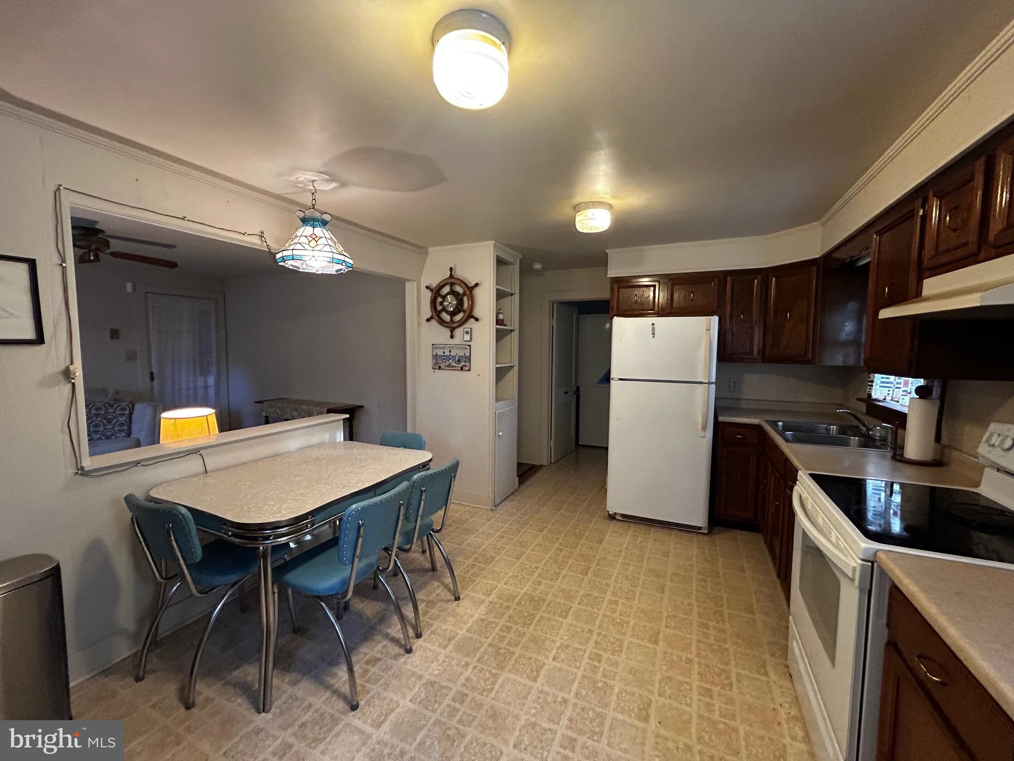 22597 Pot Pie Road Wittman, MD 21676 - Photo 6 of 10 a kitchen with refrigerator and chairs