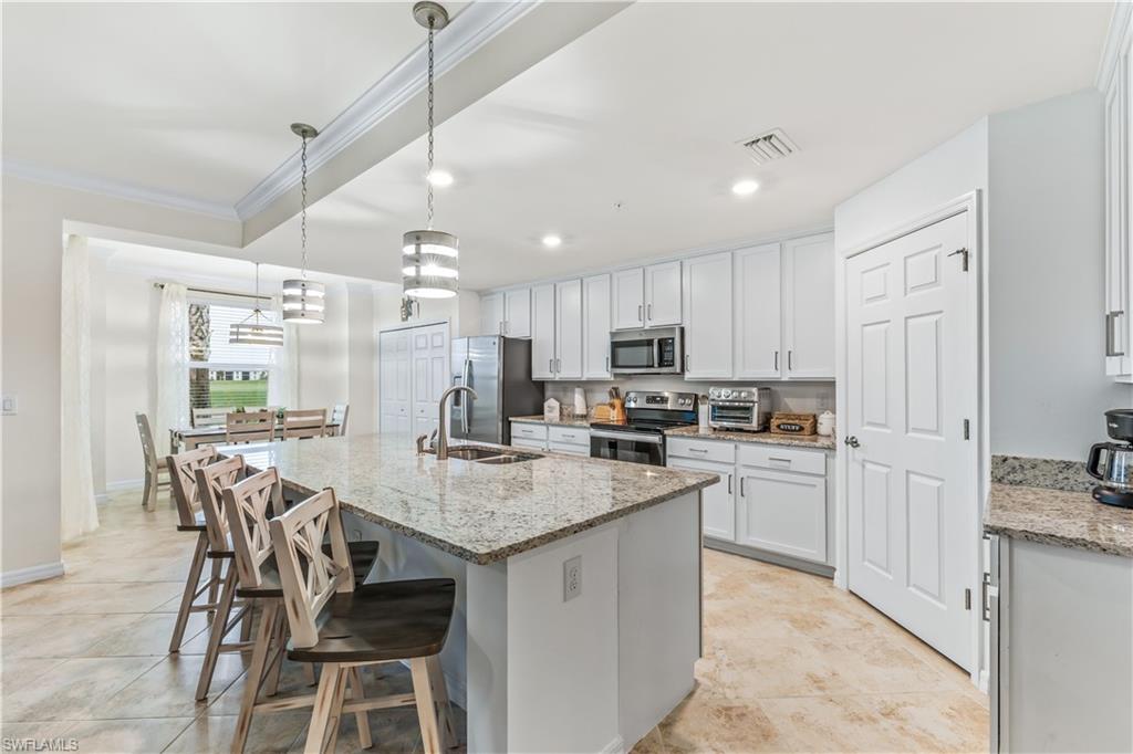 Undisclosed Address Punta Gorda, FL 33982 - Photo 7 of 14 a kitchen with kitchen island granite countertop a table chairs microwave and refrigerator