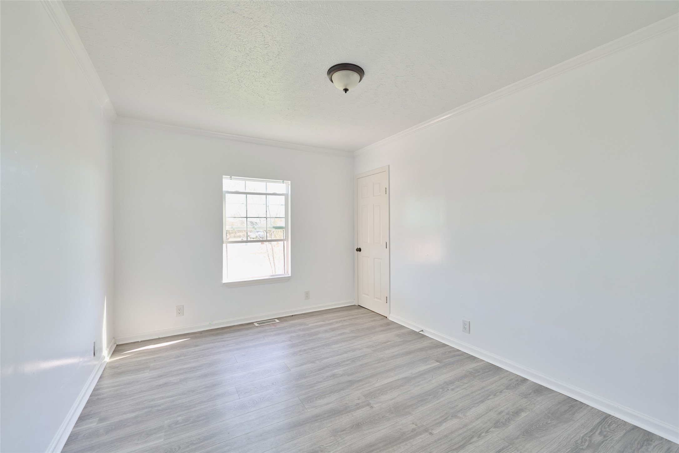 928 Coen Road Rosharon, TX 77583 - Photo 13 of 18 a view of an empty room with wooden floor and window