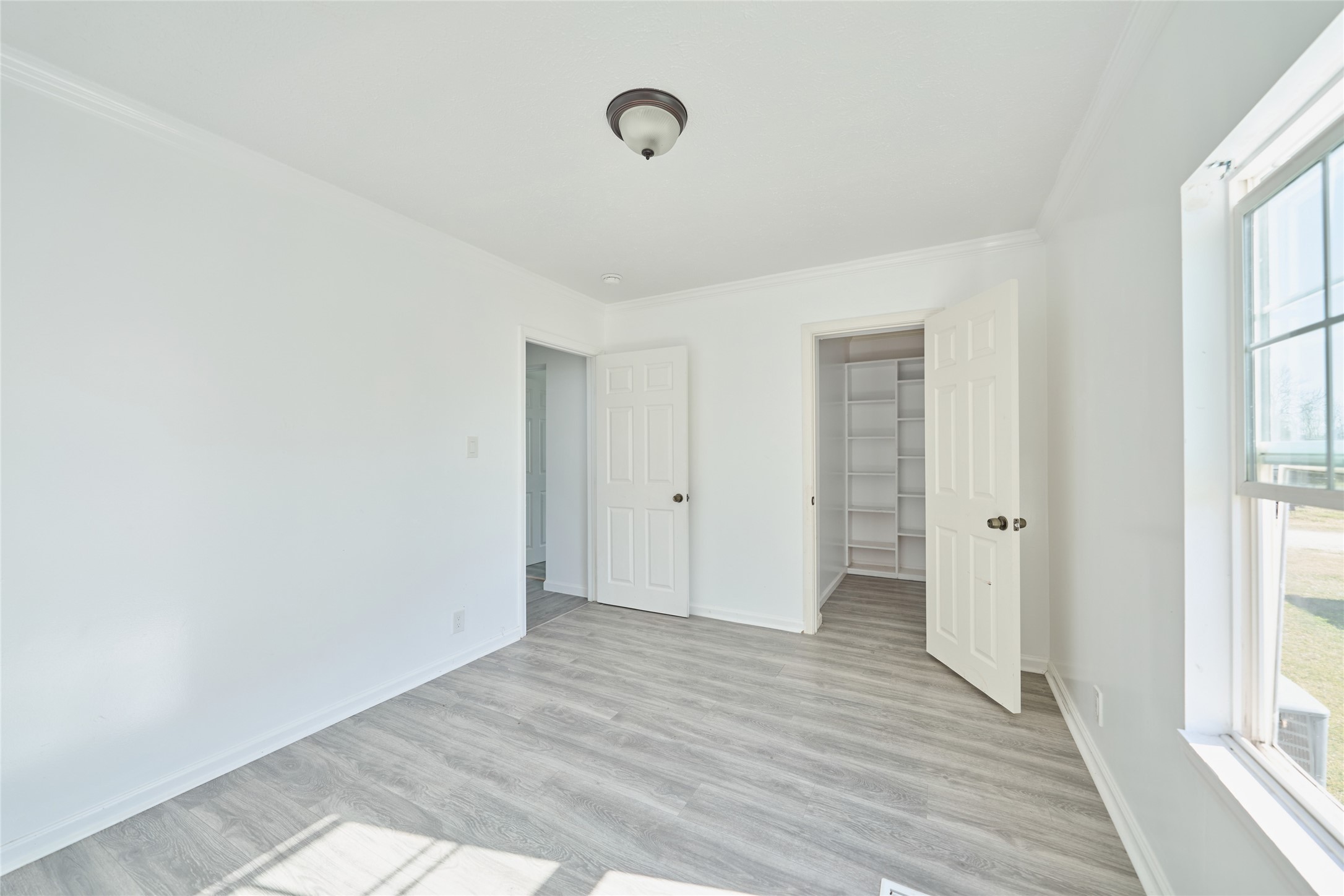 928 Coen Road Rosharon, TX 77583 - Photo 17 of 18 a view of an empty room with wooden floor and a window