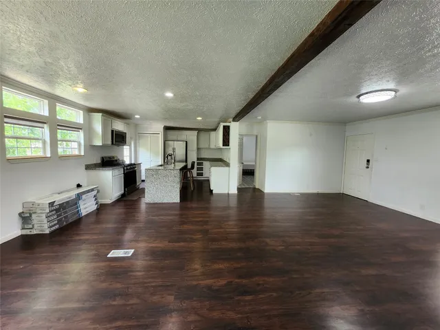 a view of a kitchen with furniture and wooden floor
