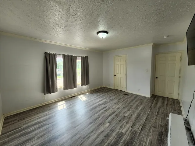 an empty room with wooden floor and mirror