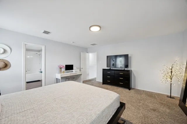 a bedroom with a bed and a tv on dresser