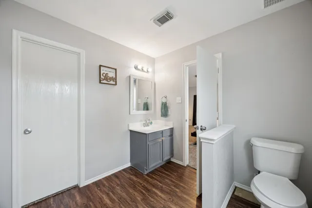 a bathroom with a toilet sink and mirror