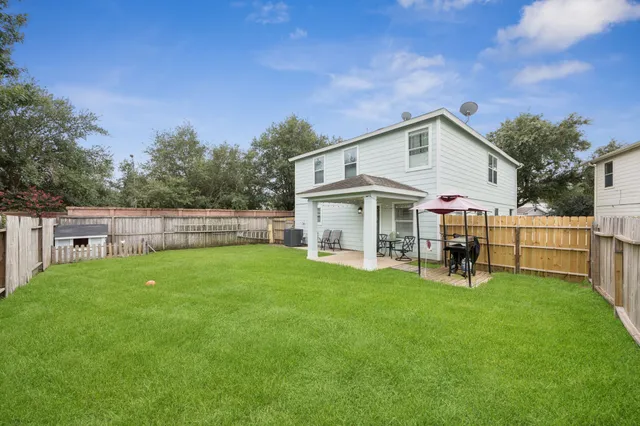 a view of a house with a yard and sitting area