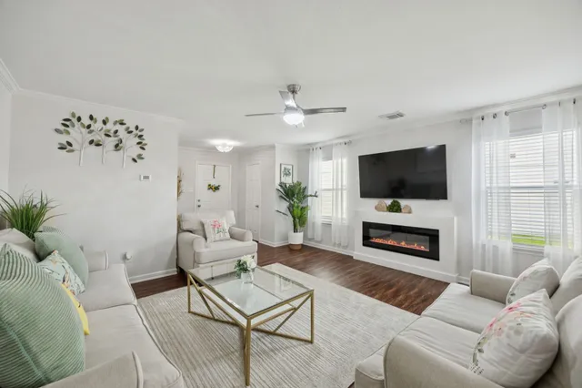 a living room with furniture a flat screen tv and a fireplace
