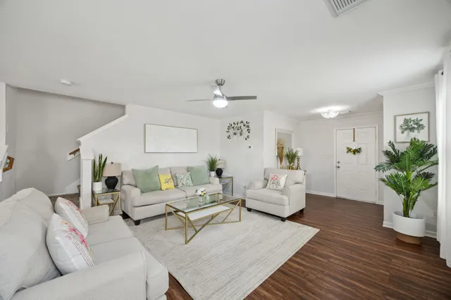 a living room with furniture and a wooden floor