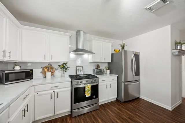 a kitchen with a white stove and refrigerator