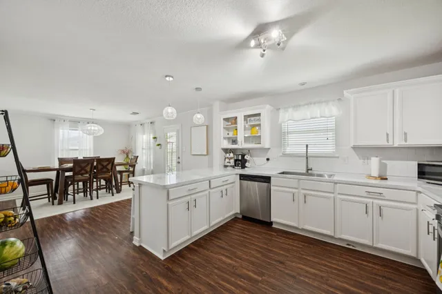 a large white kitchen with lots of counter top space and a sink