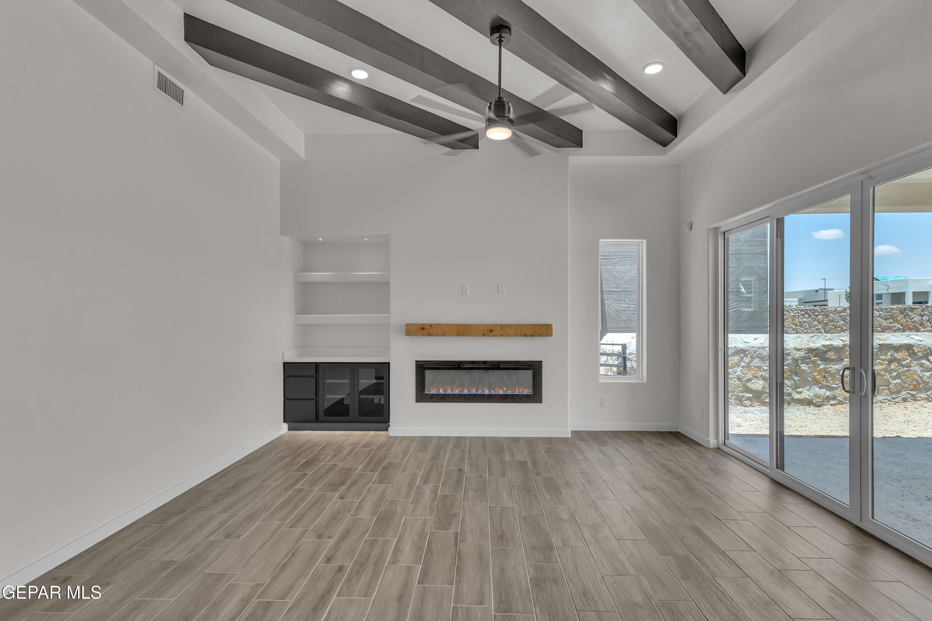 7264 Cimarron Rim Drive El Paso, TX 79911 - Photo 4 of 21 a view of an empty room with wooden floor fireplace and a window