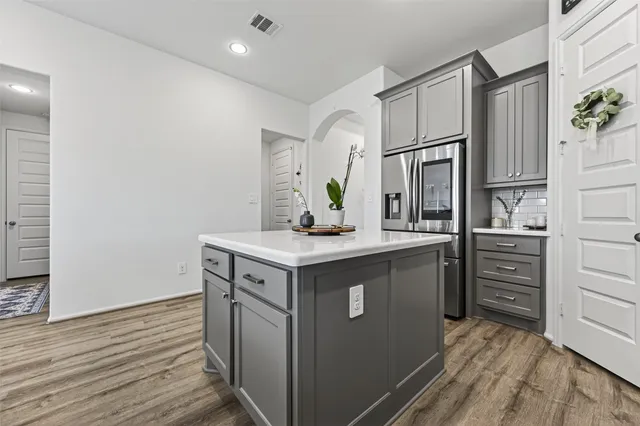 a spacious bedroom with a bed and a flat tv screen on the dresser