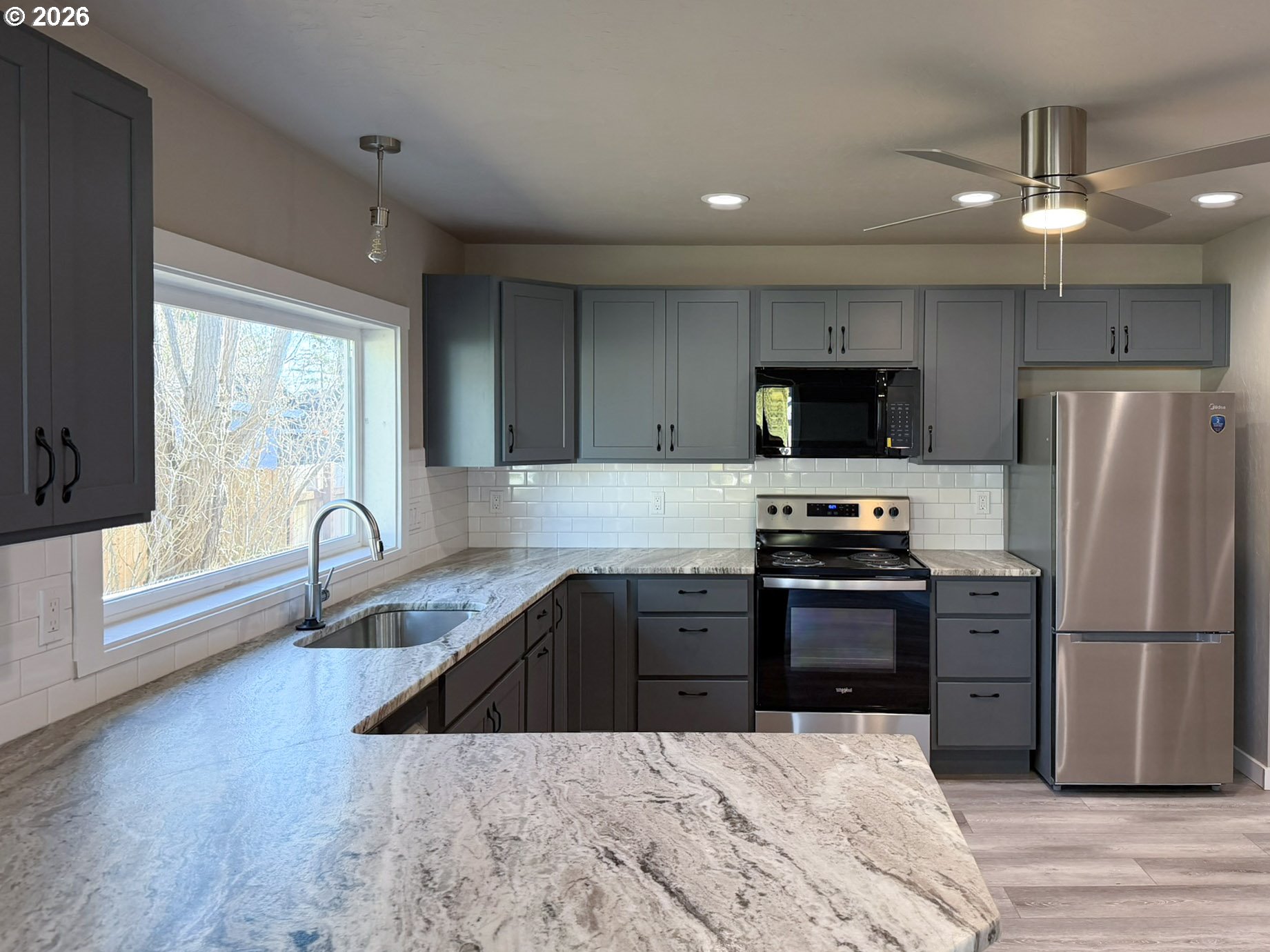 325 Railroad Street Brookings, OR 97415 - Photo 15 of 38 a kitchen with granite countertop a refrigerator and a stove top oven