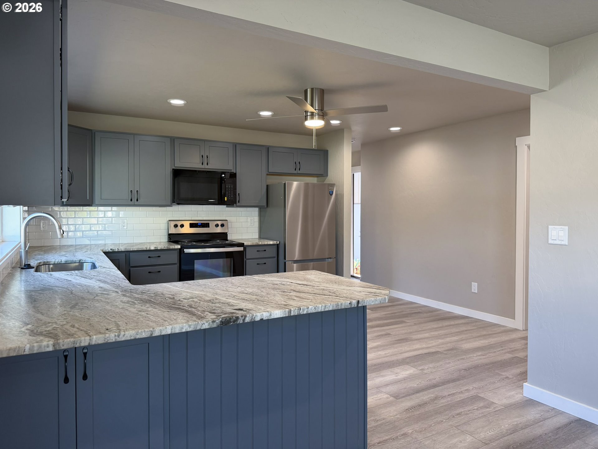 325 Railroad Street Brookings, OR 97415 - Photo 16 of 38 a kitchen with granite countertop a refrigerator and a sink