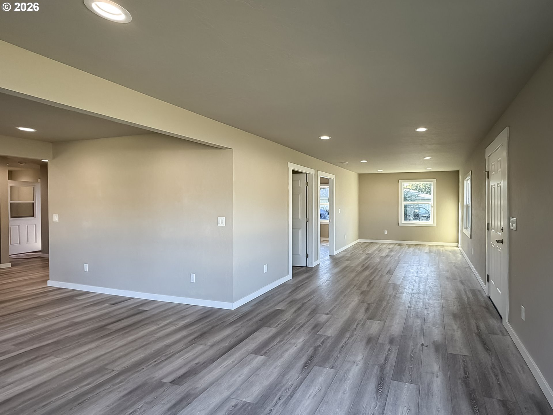325 Railroad Street Brookings, OR 97415 - Photo 21 of 38 an empty room with wooden floor and windows