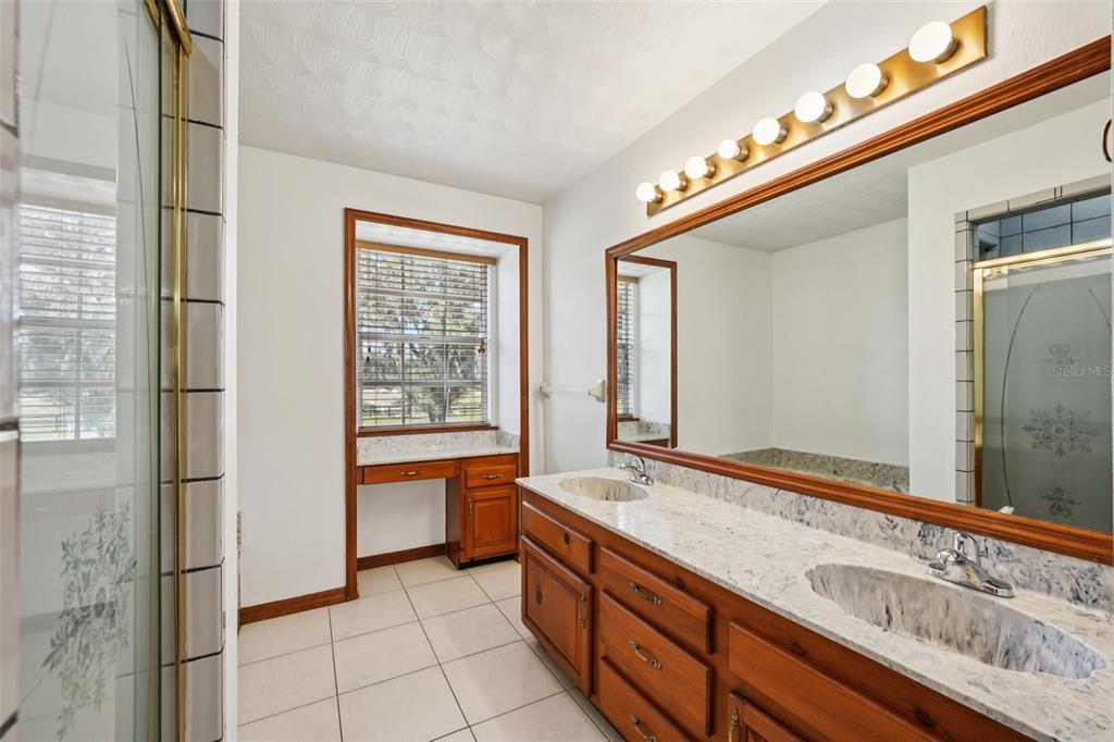 4716 Gallagher Road Plant City, FL 33565 - Photo 38 of 69 a bathroom with a granite countertop sink and a large mirror