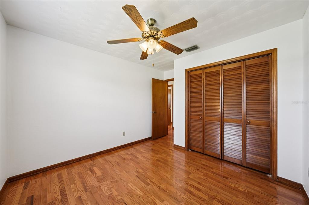 4716 Gallagher Road Plant City, FL 33565 - Photo 48 of 69 an empty room with wooden floor closet and ceiling fan