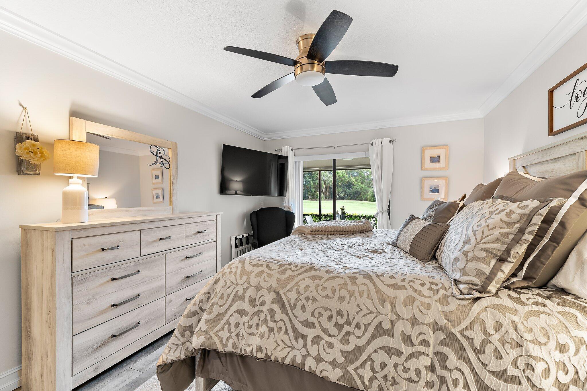 1201 Pinecrest Circle, Unit B Jupiter, FL 33458 - Photo 21 of 39 a bedroom with a large bed and a tv