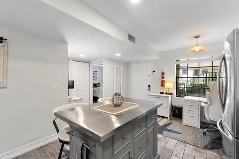 a kitchen with a table chairs sink and cabinets