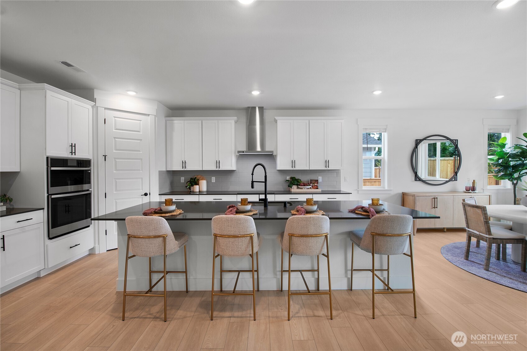 601 Sunbeam Place Sequim, WA 98382 - Photo 2 of 26 a kitchen with a dining table chairs and wooden floor