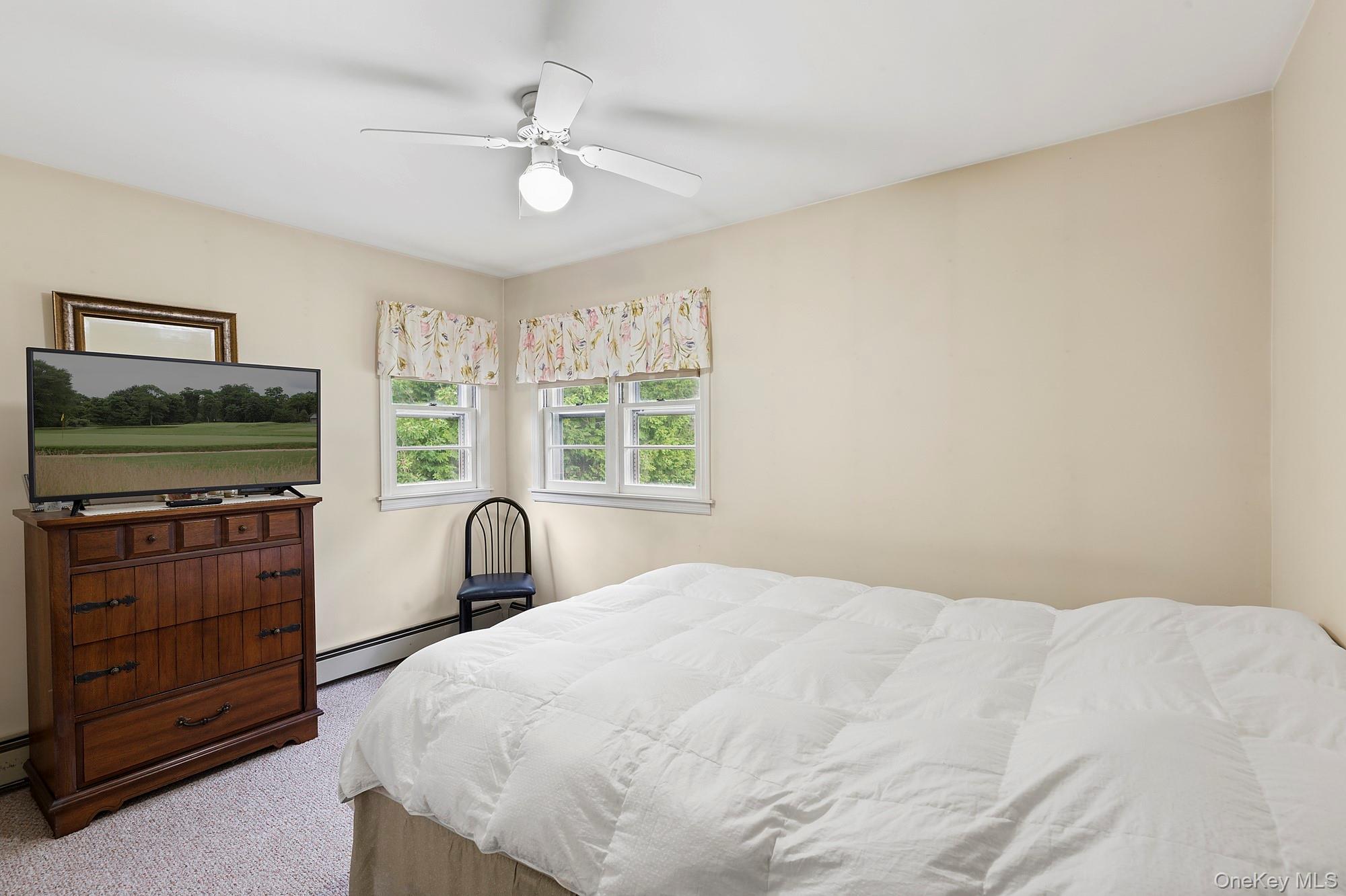 1645 Ruth Road Mattituck, NY 11952 - Photo 8 of 16 a bedroom with a bed and window with mirror