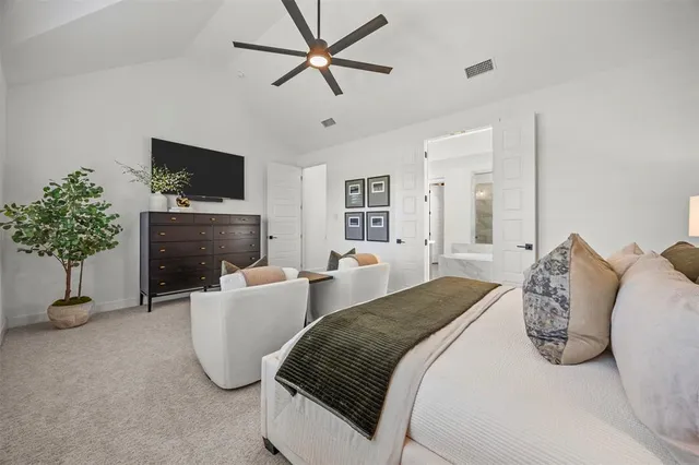 a spacious bedroom with a bed a couch and a flat screen tv