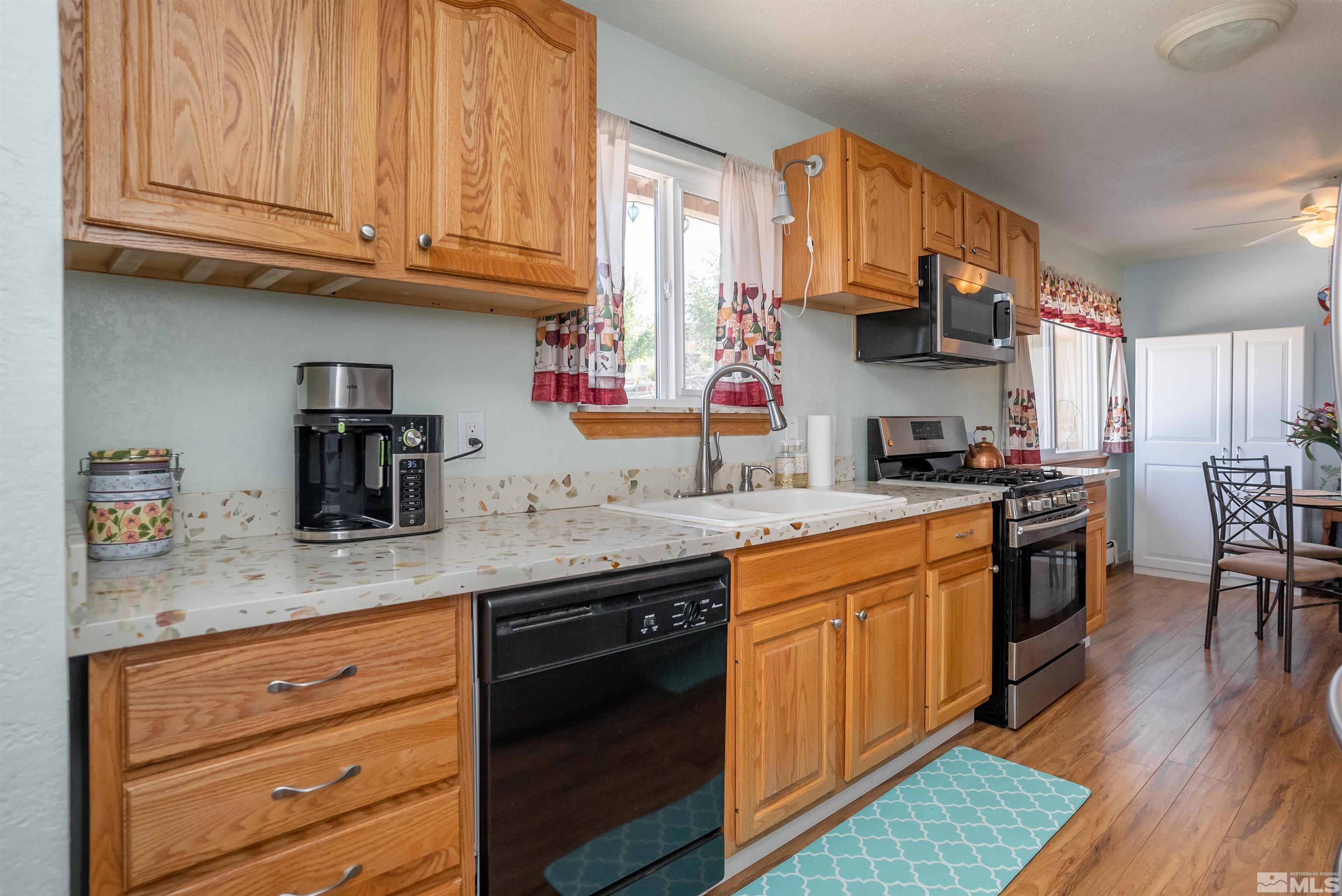 4936 Koenig Road Reno, NV 89506 - Photo 7 of 30 a kitchen with stainless steel appliances granite countertop wooden cabinets a sink and dishwasher