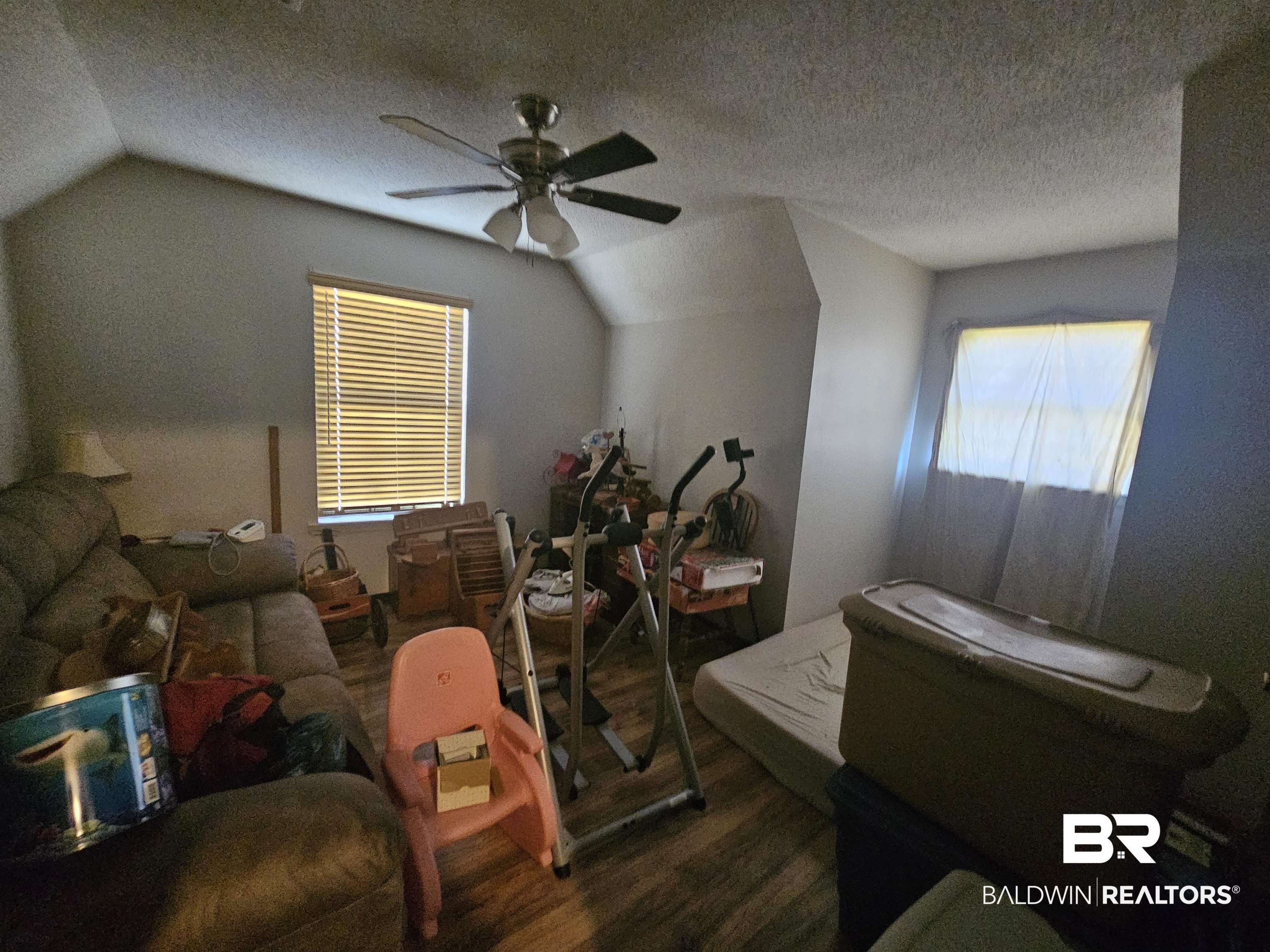 1818 Old Fannie Road Flomaton, AL 36441 - Photo 17 of 20 Bedroom featuring lofted ceiling, wood finished floors, ceiling fan, and a textured ceiling