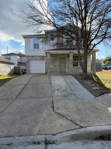 a view of a house with a yard and large tree