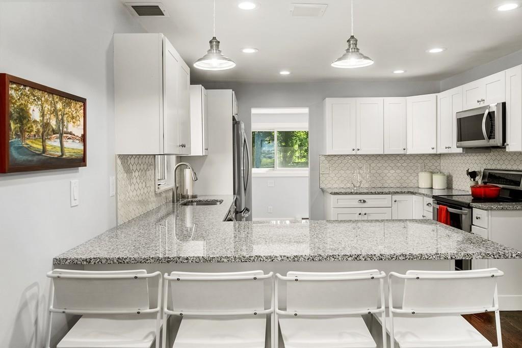 103 Stimson Street Boston, MA 02132 - Photo 3 of 26 a kitchen with stainless steel appliances granite countertop a sink and a white cabinets