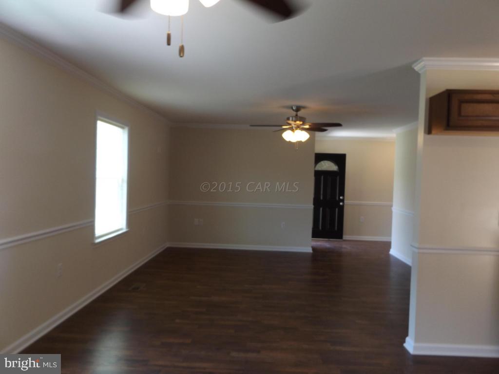 27100 Mt Vernon Road Princess Anne, MD 21853 - Photo 11 of 22 an empty room with wooden floor chandelier and windows