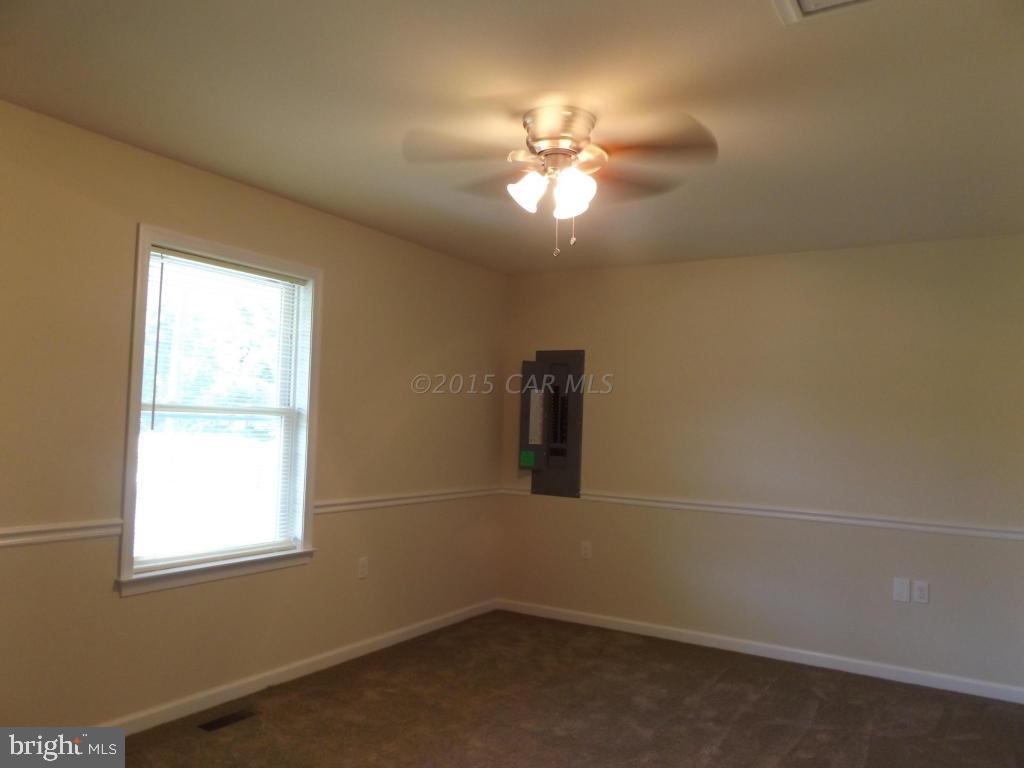 27100 Mt Vernon Road Princess Anne, MD 21853 - Photo 18 of 22 en empty room with windows and chandelier fan