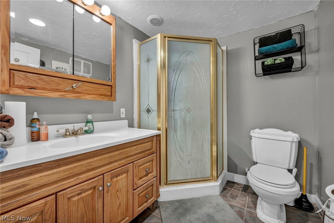 13800 Milo Road Garfield Heights, OH 44125 - Photo 24 of 39 Bathroom with vanity, a stall shower, and a textured ceiling