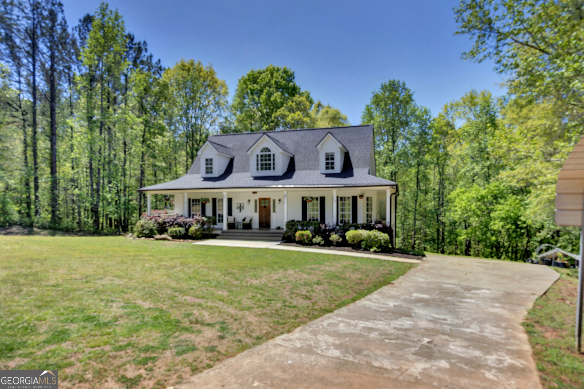 a view of a big house with a big yard and large trees