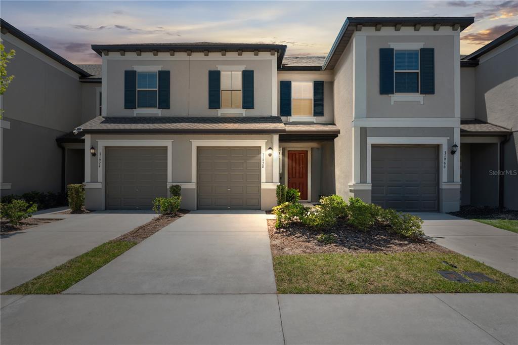 a front view of a house with yard and parking