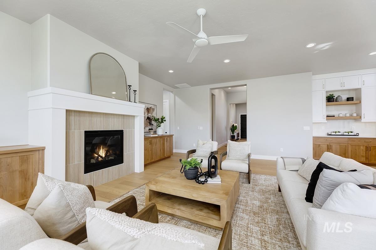 6909 Campolina Way Star, ID 83669 - Photo 11 of 39 Living area featuring light wood-type flooring, a fireplace, ceiling fan, and recessed lighting