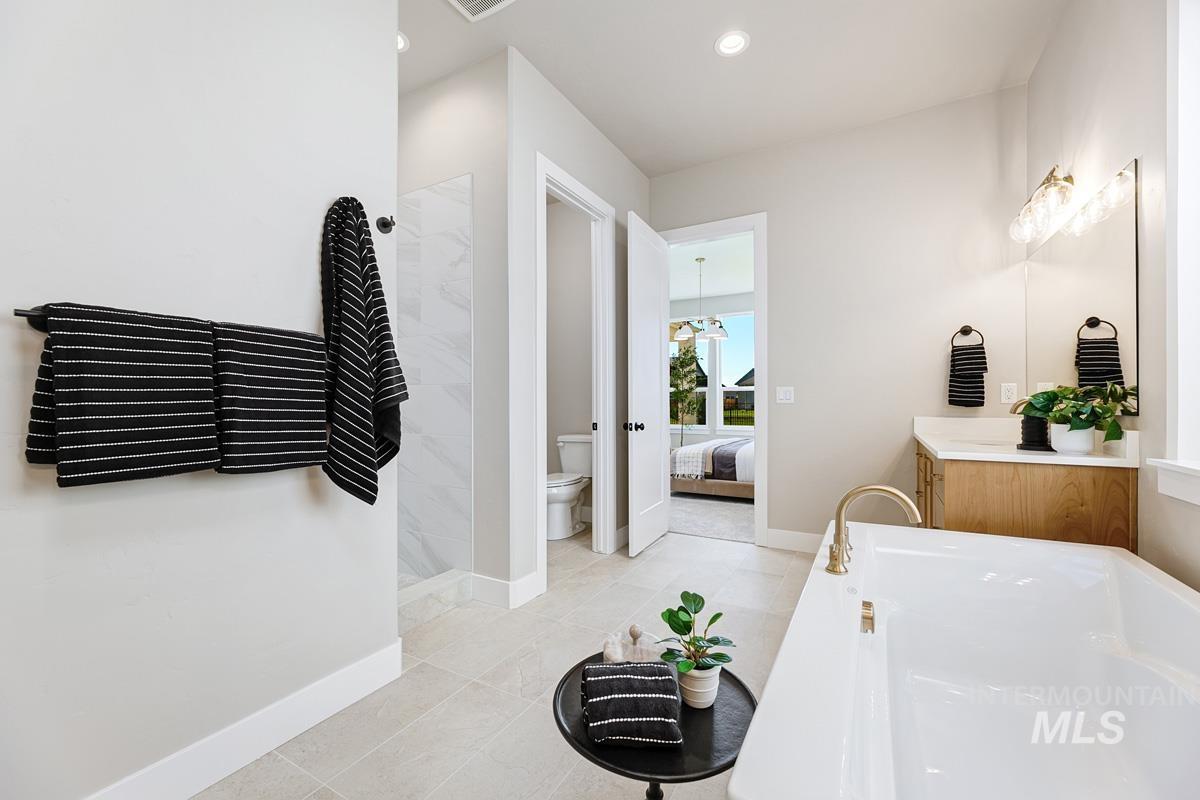 6909 Campolina Way Star, ID 83669 - Photo 20 of 39 Ensuite bathroom with vanity, walk in shower, a garden tub, light tile patterned floors, and recessed lighting
