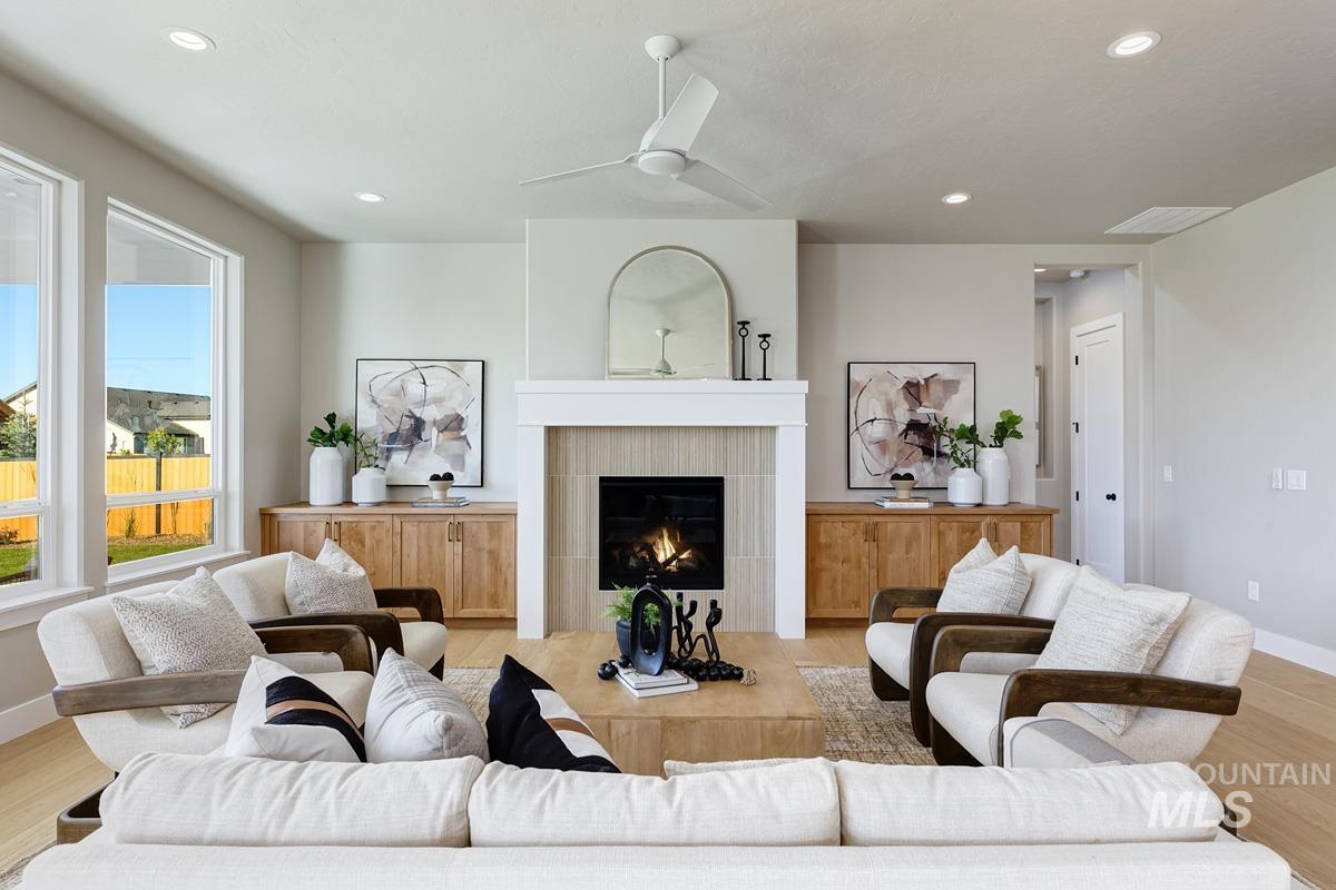 6909 Campolina Way Star, ID 83669 - Photo 2 of 39 Living room with light wood finished floors, a fireplace, recessed lighting, and ceiling fan