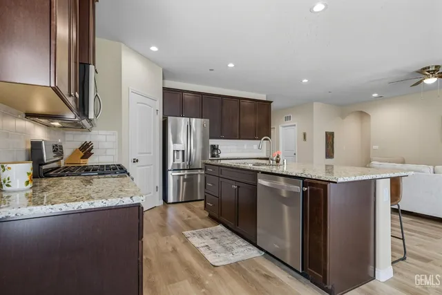 a kitchen with stainless steel appliances granite countertop a sink stove and refrigerator