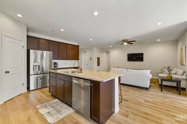 a large kitchen with stainless steel appliances granite countertop a lot of counter space and wooden floors
