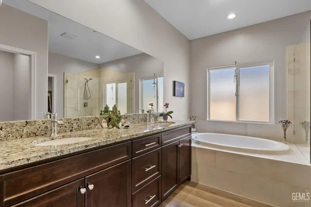 a bathroom with a granite countertop sink mirror and bathtub