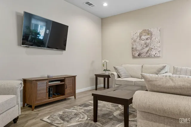 a living room with furniture a flat screen tv and a fireplace