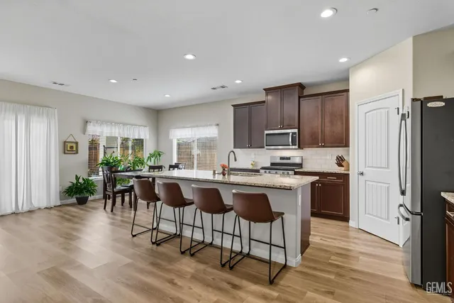 a kitchen with a table chairs refrigerator and cabinets