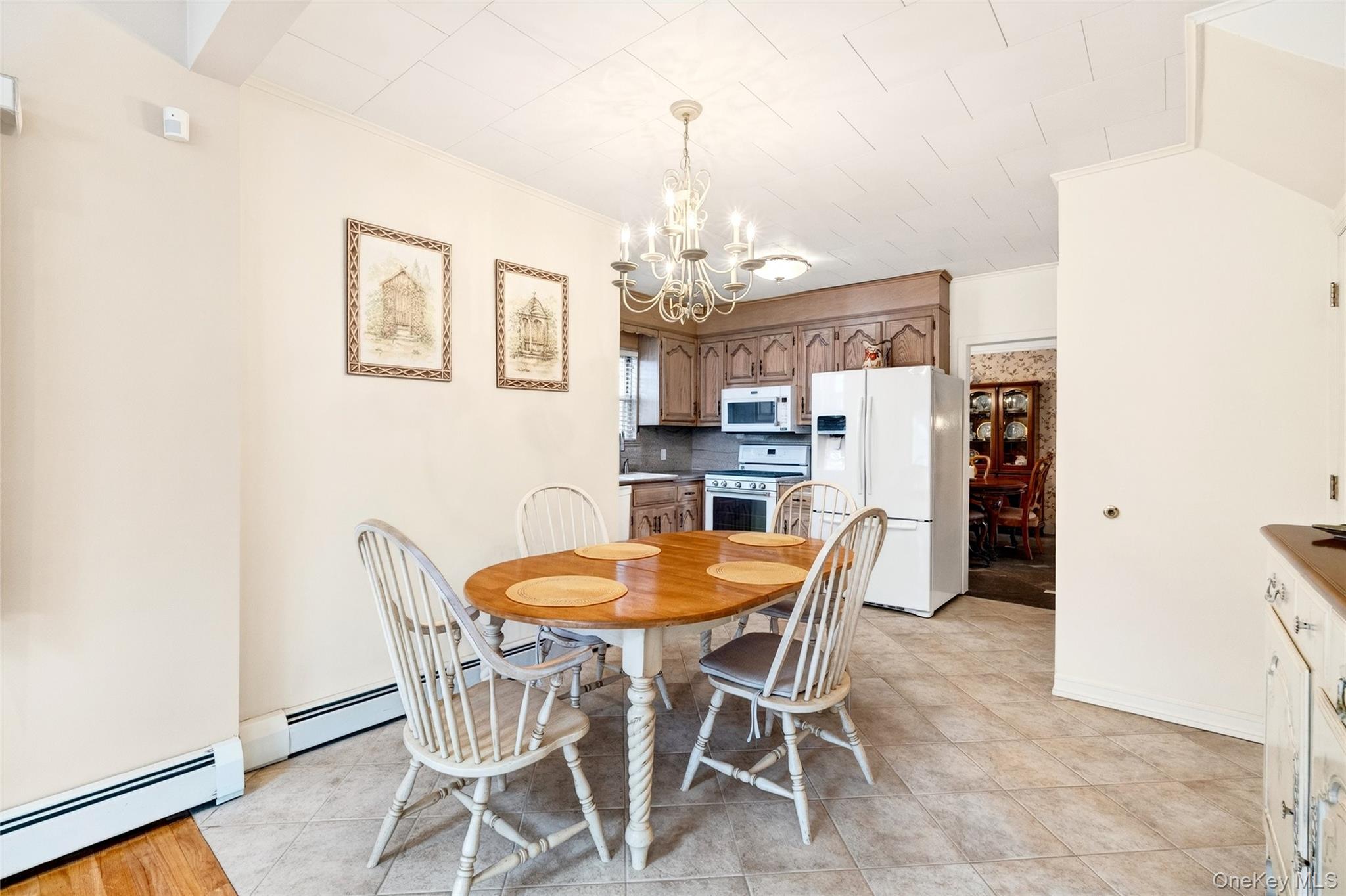 3334 Country Club Road Bronx, NY 10465 - Photo 16 of 49 Dining space featuring a baseboard radiator, a chandelier, and light tile patterned floors