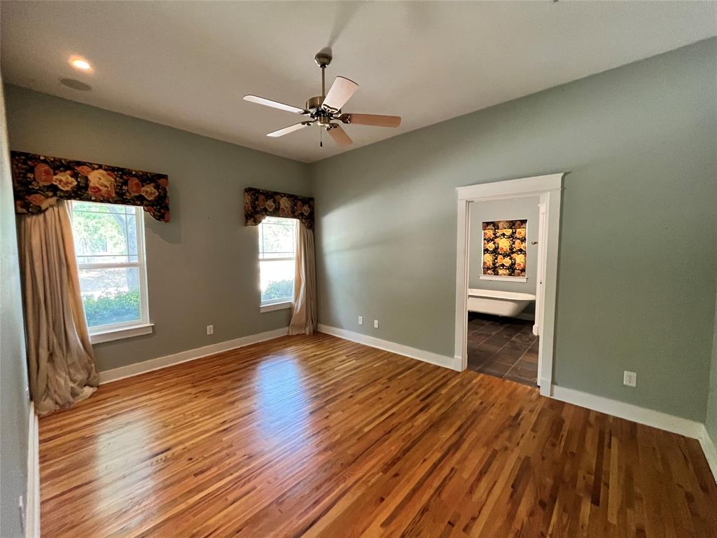 709 Roberts Street Denton, TX 76209 - Photo 11 of 35 Large primary bedroom with hardwood floors and a ceiling fan.