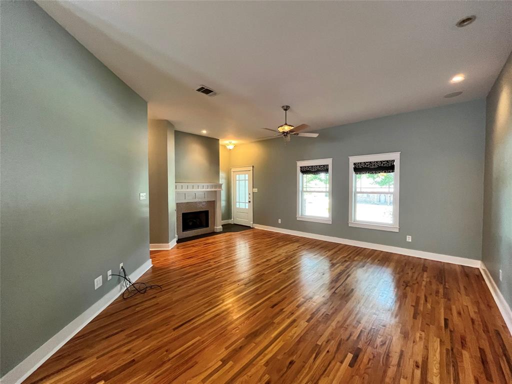 709 Roberts Street Denton, TX 76209 - Photo 3 of 35 Bright living room featuring a cozy fireplace and plenty of natural light.