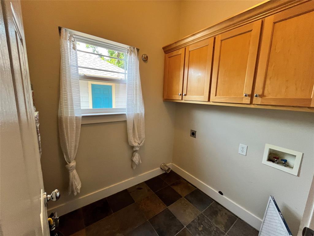 709 Roberts Street Denton, TX 76209 - Photo 7 of 35 Convenient laundry room with extra storage cabinets and a window.
