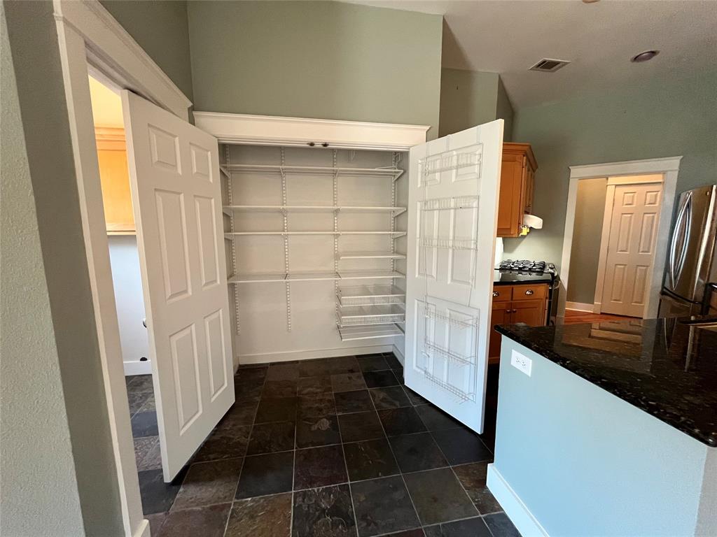 709 Roberts Street Denton, TX 76209 - Photo 9 of 35 Large walk-in pantry or storage closet with built-in shelving.